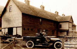 Woods Lightning Protection installed Lightning rods on this barn in Deposit, New York in 1914. Philip Woods is driving the first company truck in the foreground. Founder Frank A. Woods is in the car to the left